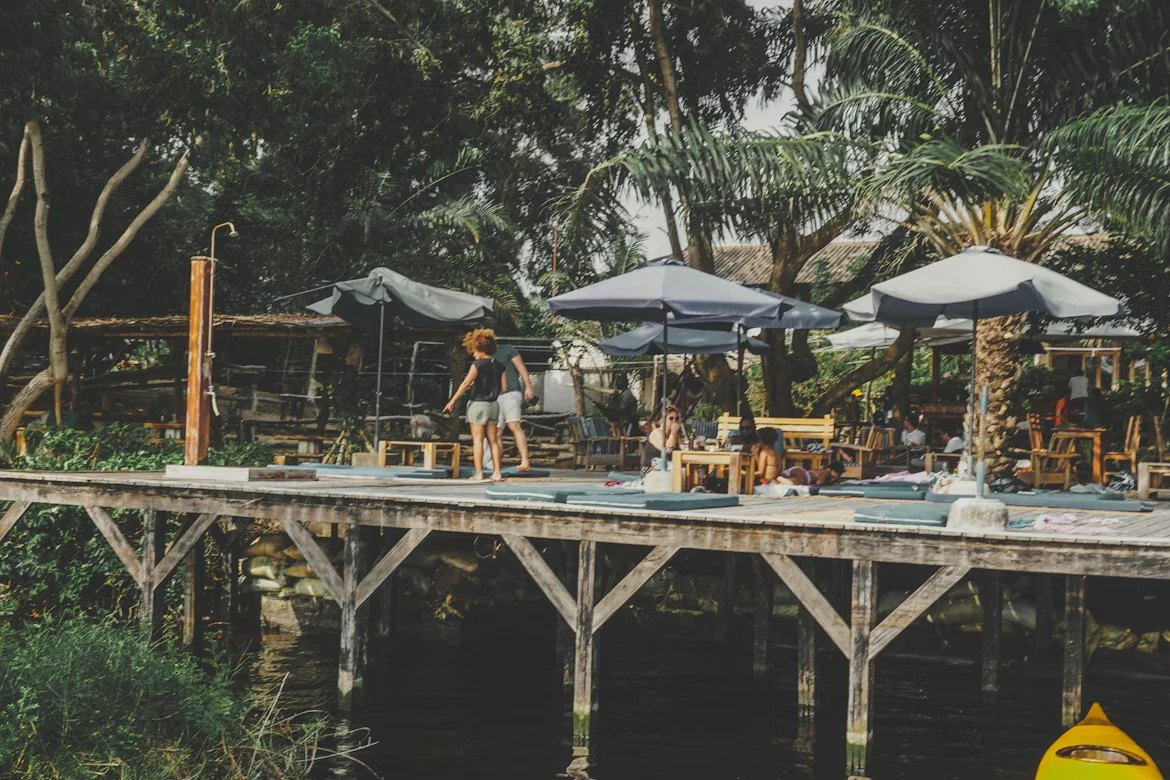 A wooden deck bar over the lagoon, under parasols